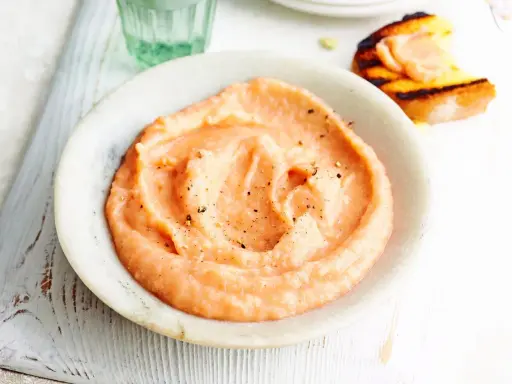 Cremiger, rosafarbener Dip mit Pfeffer bestreut, perfekt als schneller Dip zu Kartoffeln. Daneben ein geröstetes Brot mit Lachs.
