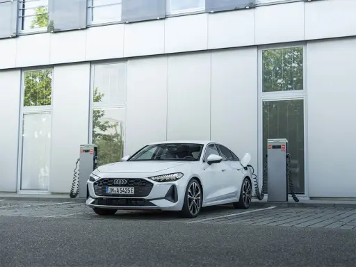 Ein weißer Audi lädt an einer Ladestation. Das zeigt, was ist ein Hybridauto: flexibel und umweltfreundlich unterwegs.