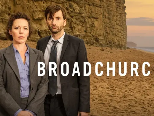 Två poliser står på en strand framför en klippa. Serien Broadchurch är en av de bästa kriminalserier topplista.