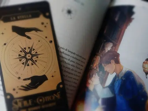 Segnalibro con "La Stella" e illustrazione di una coppia, tra pagine di libri romance fantasy.