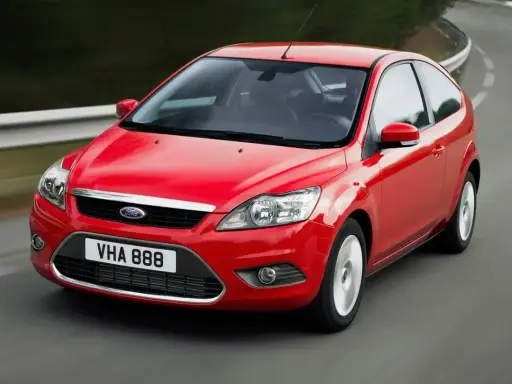 Czerwony Ford Focus MK2 1.6 benzyna w wersji 3-drzwiowej, jadący po zakręcie drogi.