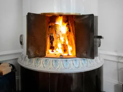 En öppen kamin med flammande ved. Det kan vara farligt att elda i kamin om man inte är försiktig.