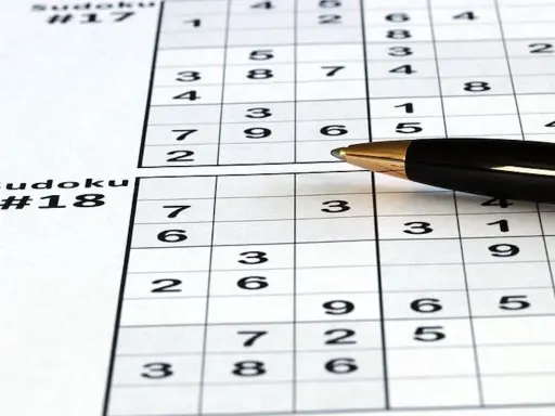 Zapisane sudoku dla seniorów, z numerami #17 i #18. Długopis czeka na rozwiązanie.
