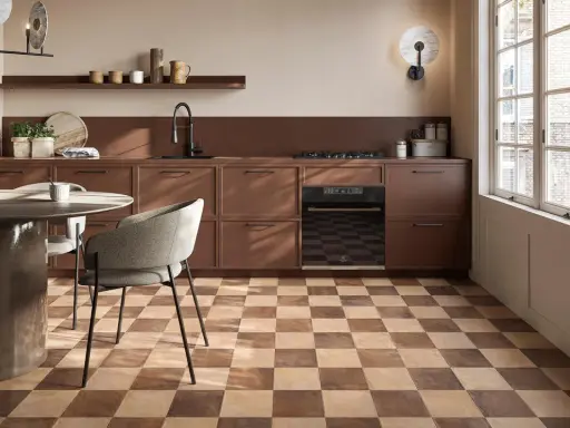 Cucina moderna con pavimento a scacchiera che crea una **tabella colori caldi**. Mobili marroni, tavolo rotondo e sedie grigie.