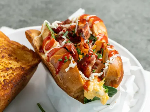 Herzhaftes **egg drop sandwich** mit Speck, Käse und Ketchup, daneben ein gegrilltes Käsebrot.