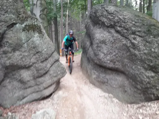 Rowerzysta pokonuje wąską ścieżkę między głazami na trasie w okolicach Lubania.