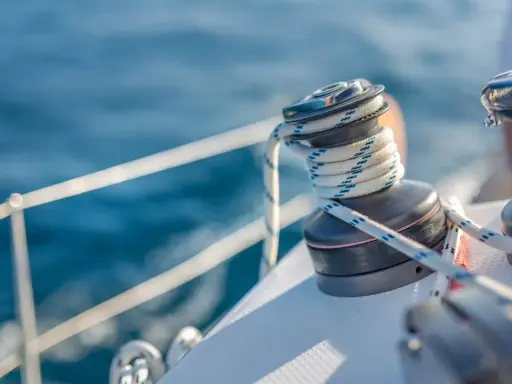 Un treuil de bateau avec une corde enroulée, un élément essentiel du vocabulaire de marin pour naviguer sur l'eau bleue.