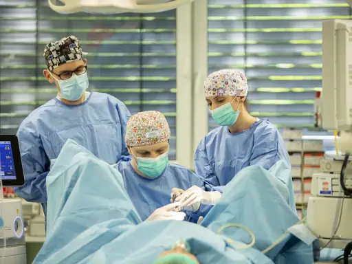 Zespół medyczny podczas operacji, monitorując parametry życiowe pacjenta, co jest kluczowe w procesie odrastania prostaty po operacji.