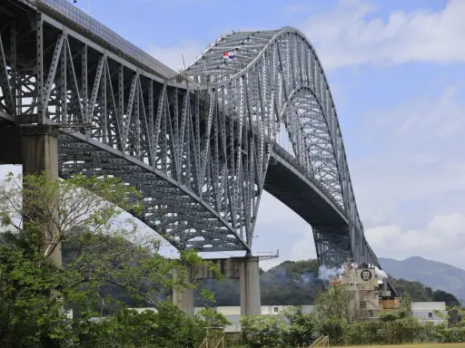 El **Puente de las Américas** cruza el Canal de Panamá, una imponente estructura de acero gris con un arco majestuoso.
