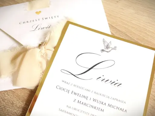 Eleganckie zaproszenie na chrzest święty dla Liwii. Złota ramka i gołąbek symbolizują uroczystość. Wzór jak wypisać zaproszenie na chrzest.