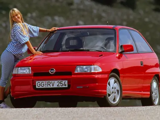 Mujer rubia posa junto a un coche histórico rojo. ¿Cuántos años tiene este coche?