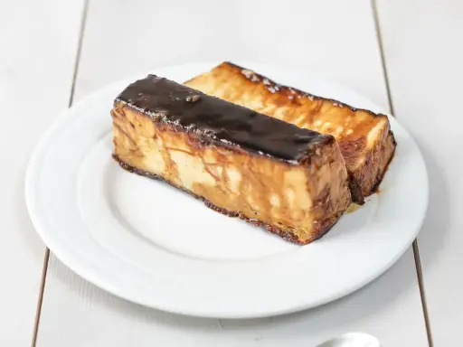 Dos porciones de pan de calatrava, un postre tradicional español, con una capa brillante de caramelo oscuro.