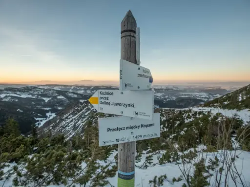 Zimowy szlak w Tatrach. Znak informuje o przełęczy między Kopami (1499 m n.p.m.) i kieruje do Kuźnic przez Dolinę Jaworzynki.