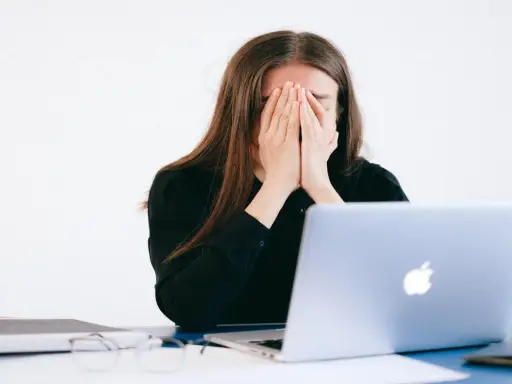 Donna disperata davanti al PC, vittima di un reato revenge porn.