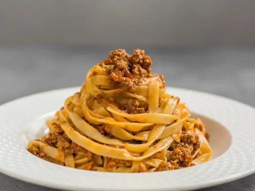 Porcja tagliatelle z bogatym sosem mięsnym, klasyczne spaghetti bolognese w nowej odsłonie.