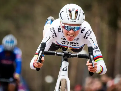 Fem van Empel zeigt Zunge beim Radrennen, trägt weißes Trikot mit Jumbo Visma Logo.