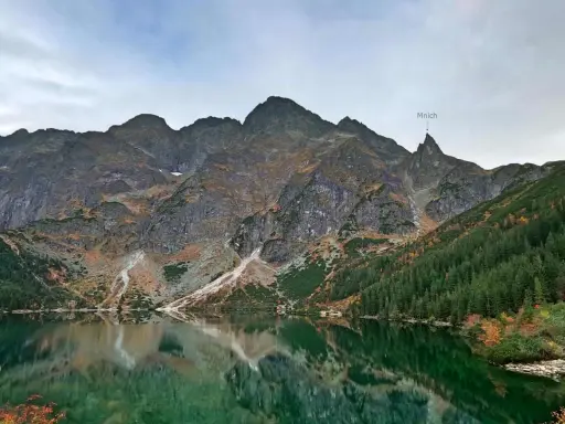 Majestatyczny Mnich góruje nad Morskim Okiem, odbijając się w jego zielonych wodach.