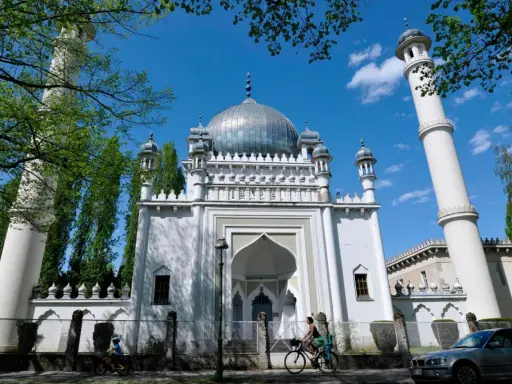 Weiße Moschee mit Kuppel und Minaretten, ein Beispiel für orientalische Architektur, im Sonnenschein.