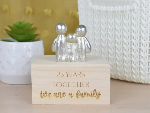 Srebrna figurka rodziny na drewnianym pudełku z napisem "23 YEARS TOGETHER We are a family". Idealny prezent na 23 rocznicę ślubu.