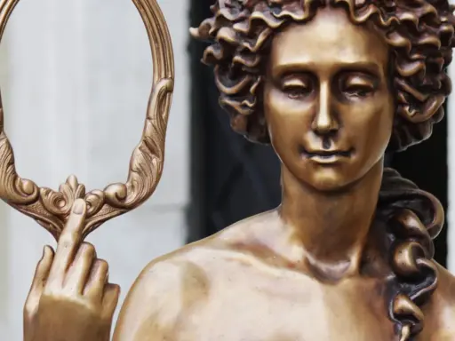 Bronzestatue der Aphrodite, die einen verzierten Spiegel hält. Ihr lockiges Haar und ihr sanfter Blick unterstreichen ihr klassisches Aphrodite-Aussehen.