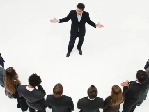 Un líder inspira a su equipo. Un grupo de personas en círculo escuchan atentamente a un hombre que demuestra master liderazgo y gestión de equipos.