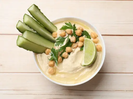 Krämig hummus med kikärtor, persilja, gurkstavar och lime. Ett enkelt hummus recept för en god dipp.