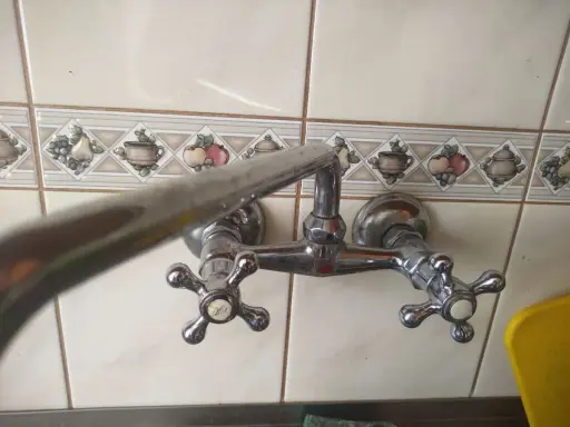 Chromowana bateria dwuuchwytowa z ozdobnymi kafelkami. Wymiana głowicy w baterii dwuuchwytowej to prosty sposób na naprawę cieknącego kranu.