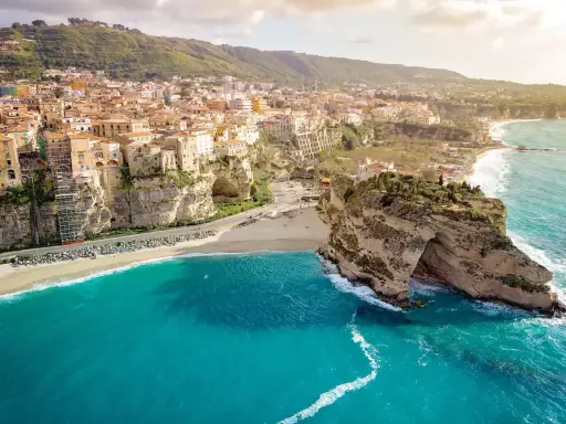 Panoramica mozzafiato delle calabria spiagge con case colorate aggrappate alle scogliere e un mare cristallino.