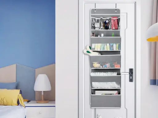Grauer **Pocket Schrank** an der Tür mit vielen Fächern, gefüllt mit Kosmetik, Spielzeug und Windeln.