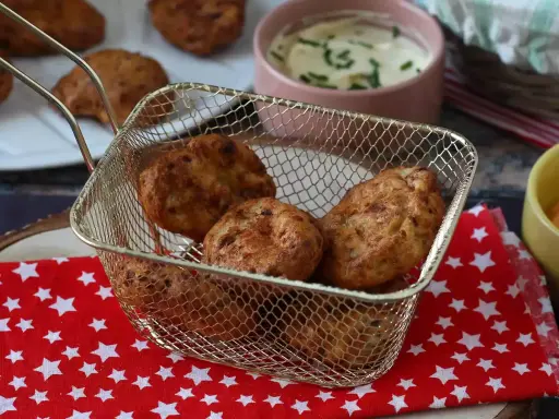Gyldene chicken nuggets i en friteringskurv, nylagade i airfryer. Serveras med en krämig dipp.