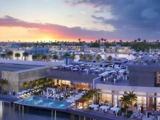 Un moderno complesso sul Jeddah port con piscina a sfioro, ristoranti all'aperto e yacht ormeggiati al tramonto.