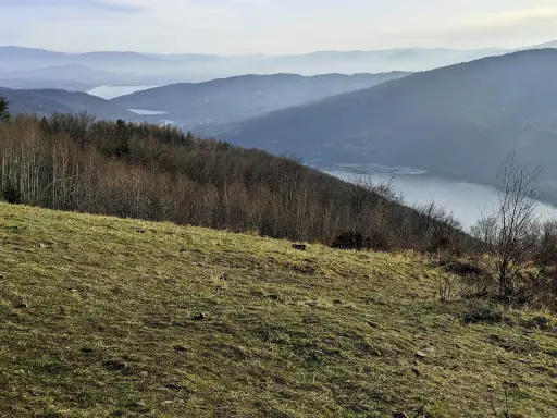 Widok na jezioro i góry w Beskidach. Idealne miejsce na krótkie szlaki w Beskidach, gdzie można podziwiać malownicze krajobrazy.