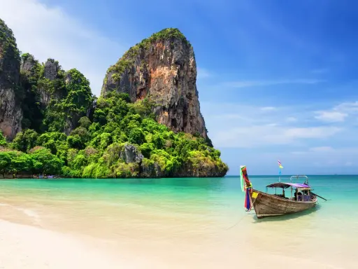 Idealna pogoda na Phuket w listopadzie: spokojne morze, piaszczysta plaża i tradycyjna łódź.