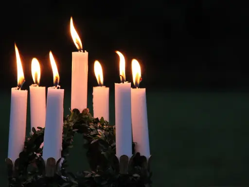 Sju ljus brinner i en krans, en påminnelse om vad betyder namnet Lucia: ljus.
