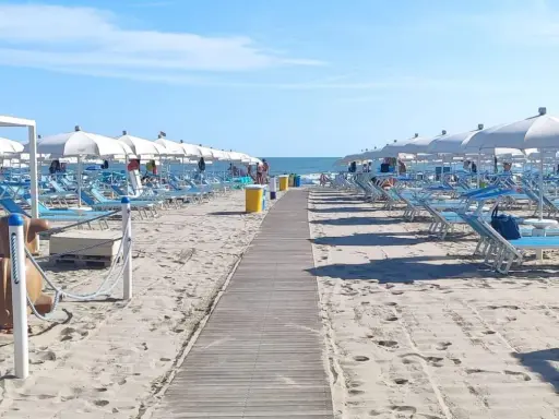 Spiaggia di Misano Adriatico: file di lettini e ombrelloni bianchi pronti per accogliere i bagnanti. Cosa vedere? Il mare azzurro e la sabbia dorata!