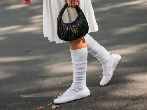 Piernas con bailarinas blancas y calcetines blancos arrugados, un look chic para bailarinas con calcetines.