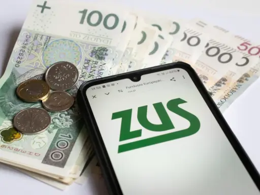 Pieniądze i telefon z logo ZUS. Sprawdź, ile płatne jest opieka nad chorym członkiem rodziny.