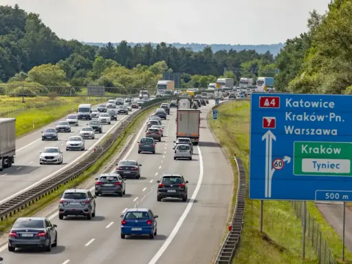 Korek na autostradzie A4 w kierunku Katowic. Samochody stoją w długim sznurze, a znaki drogowe wskazują drogę do Krakowa i Tynca.