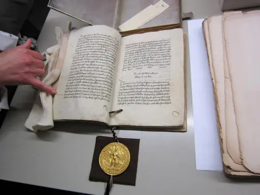 Goldene Bulle 1356: Offenes Buch mit Siegel und Hand.