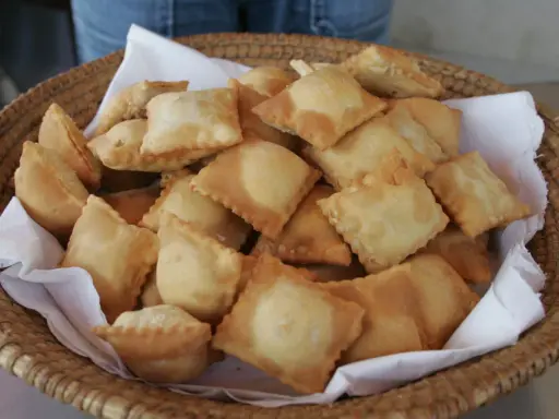 Un panier rempli de beignets dorés, une spécialité des Hautes-Alpes, prêts à être dégustés.