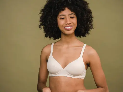 Donna sorridente con un reggiseno color carne. Un reggiseno troppo stretto conseguenze possono essere scomode, ma questo sembra comodo.
