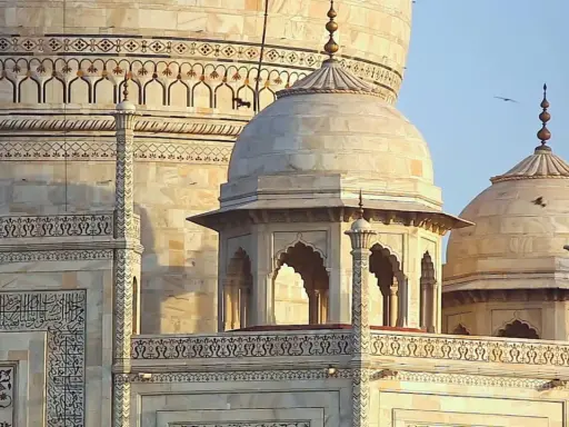 Detailansicht des Taj Mahal, ein Meisterwerk islamischer Architektur mit kunstvollen Verzierungen und Kuppeln.