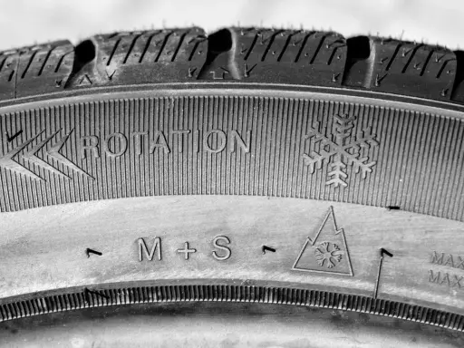Neumático M+S con indicación de rotación y símbolo de copo de nieve, listo para el invierno.