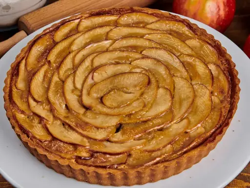 Tarta de manzana dorada, con finas láminas de manzana dispuestas en espiral sobre una base crujiente. ¡Perfecta para disfrutar!