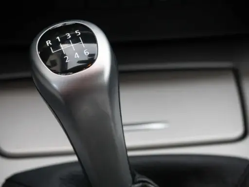 Palanca de cambios de un coche manual, con el patrón de marchas visible. Parece que el cambio de marchas roto impide seleccionar la marcha deseada.