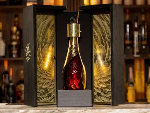 Elegancka, złota butelka z 30 letnią whisky Eagle Rare w ozdobnym, drewnianym pudełku z motywem piór.