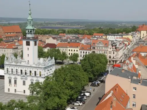 Widok na rynek w Chełmnie z ratuszem i wieżą. W tle kamienice i zieleń, idealne chełmno atrakcje.