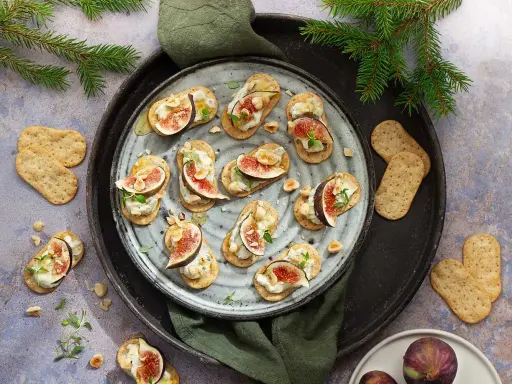 Smakliga snittar med fikon, ost och nötter på kex. Ett perfekt recept för festen!