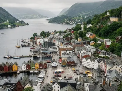 Il pittoresco porto di Bergen, con le sue case colorate affacciate sull'acqua e le colline verdi che fanno da sfondo.