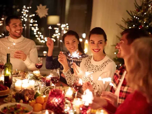 Vänner firar jul i Sverige med tomtebloss och en festlig middag.